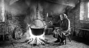 antica preparazione della polenta in casa, anziana signora.